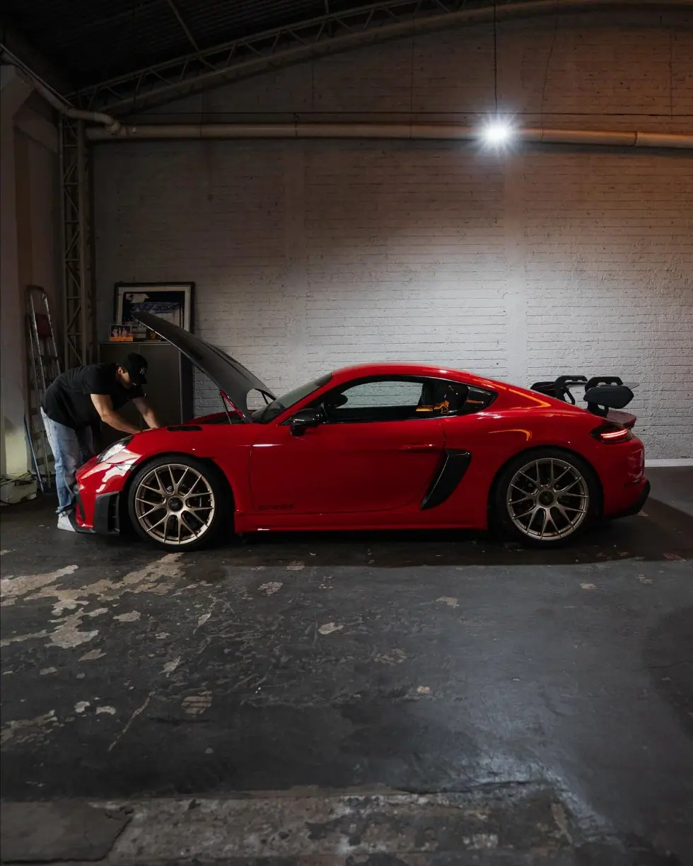 Porsche 718 GT4 RS com capô aberto na oficina APEX